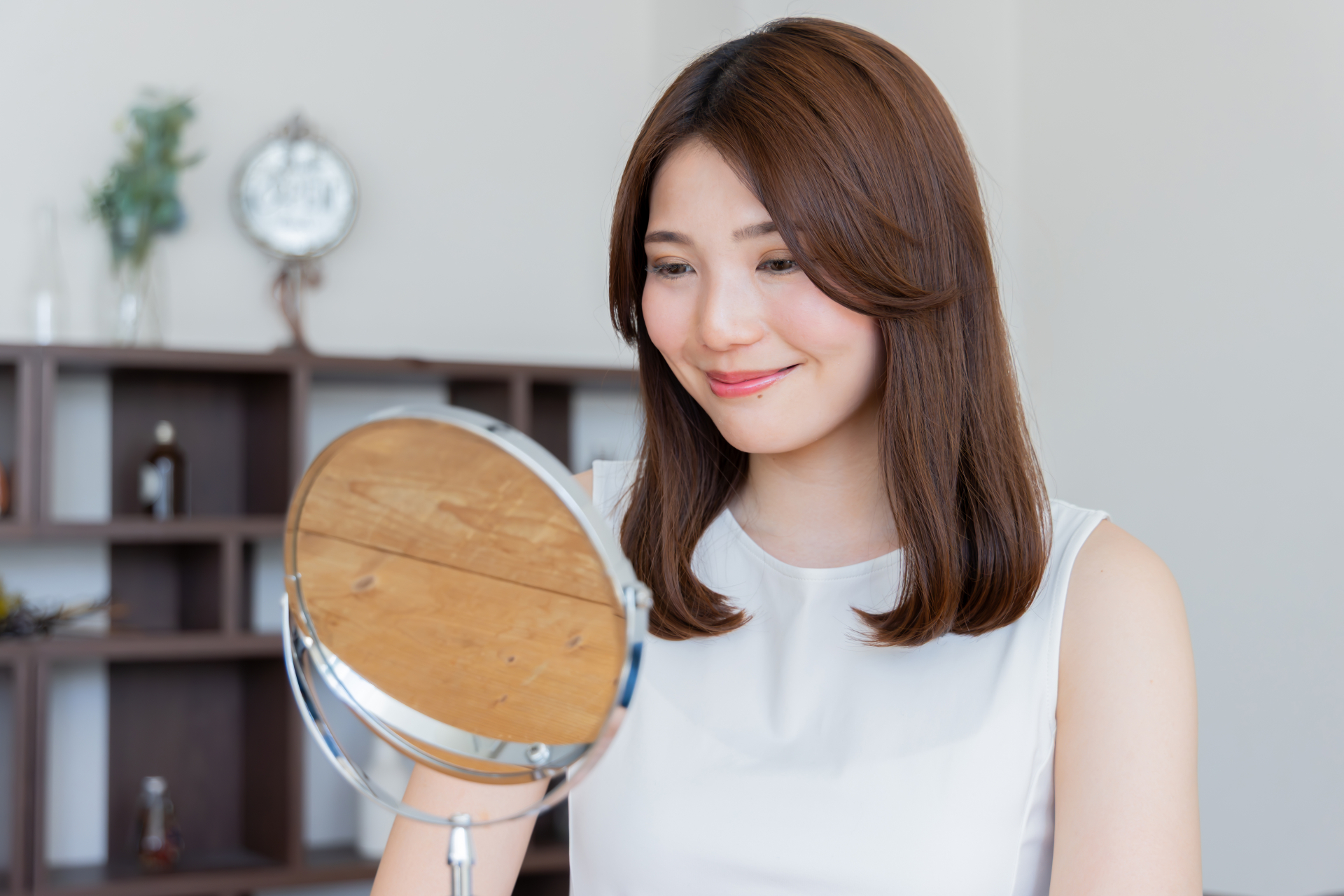 女性が鏡を見て笑顔のイメージ